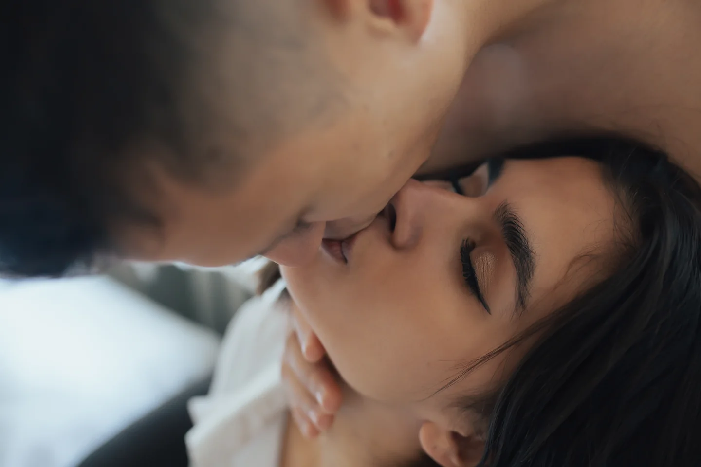 Close-up of an adult couple sharing a kiss with their eyes closed