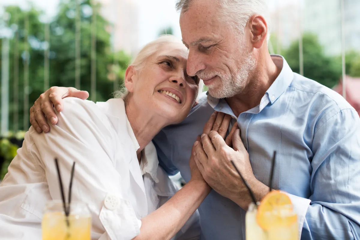 Mature adult couple sharing gentle affection, editorial imagery for HSV dating after bereavement