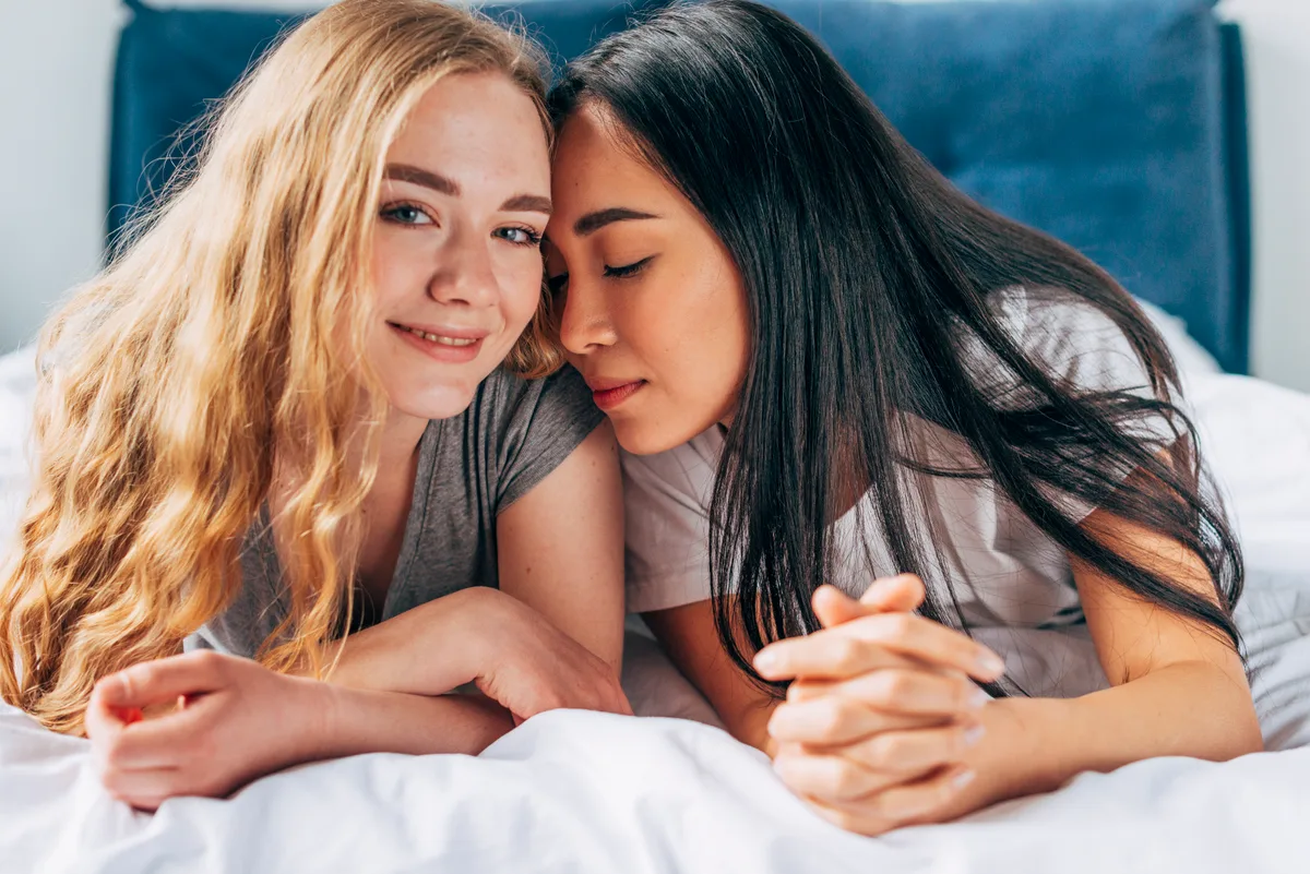 Two adult women resting close together illustrating lesbian HSV dating